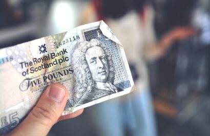 Hand holding a 5 pound note from the royal bank of scotland